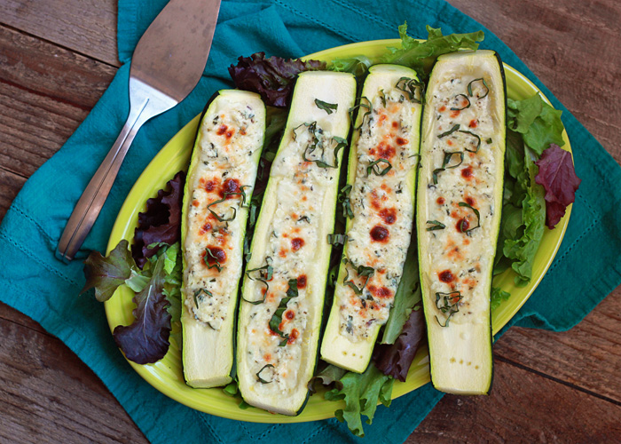A plate of four cheese-stuffed zucchini boats ready to serve. 