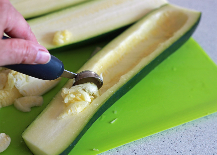 Using a melon baller to scoop out the zucchini boats. 