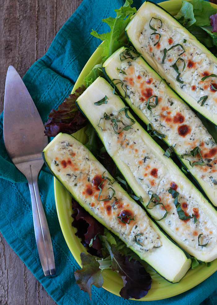 A plate of four cheese-stuffed zucchini boats. 