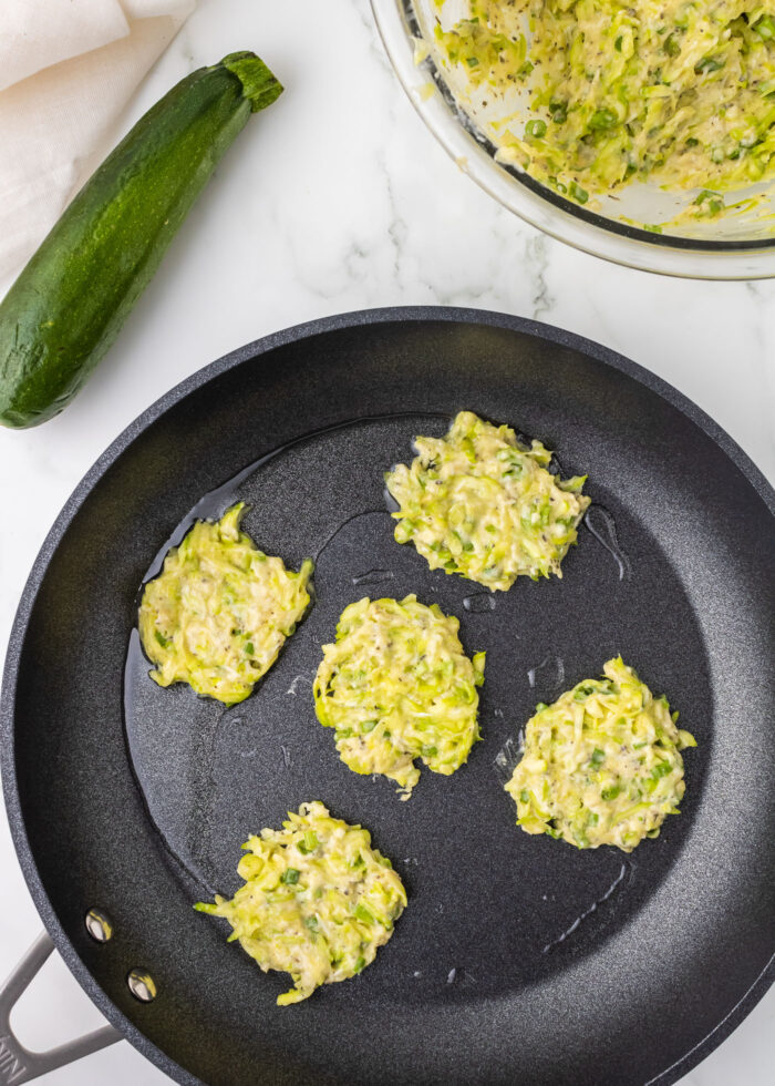 Zucchini fritters cooking in a pan
